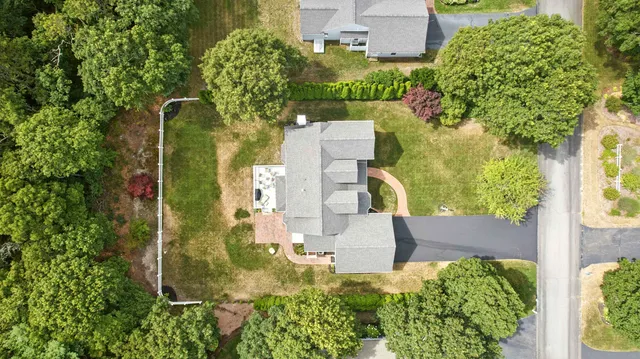 an aerial view of residential house with outdoor space and trees all around