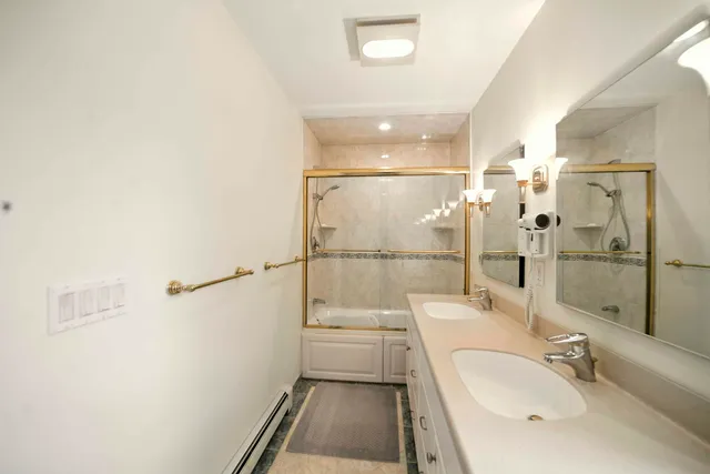 a bathroom with a double vanity sink toilet and shower