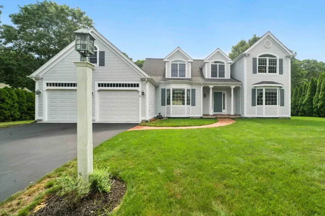 a front view of a house with a garden and yard