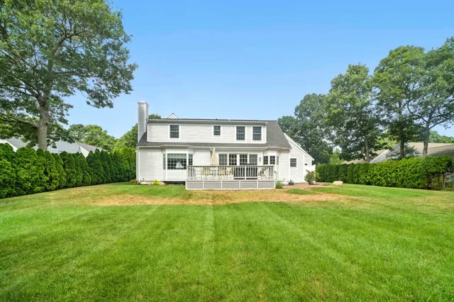 a view of a house with a big yard and large trees