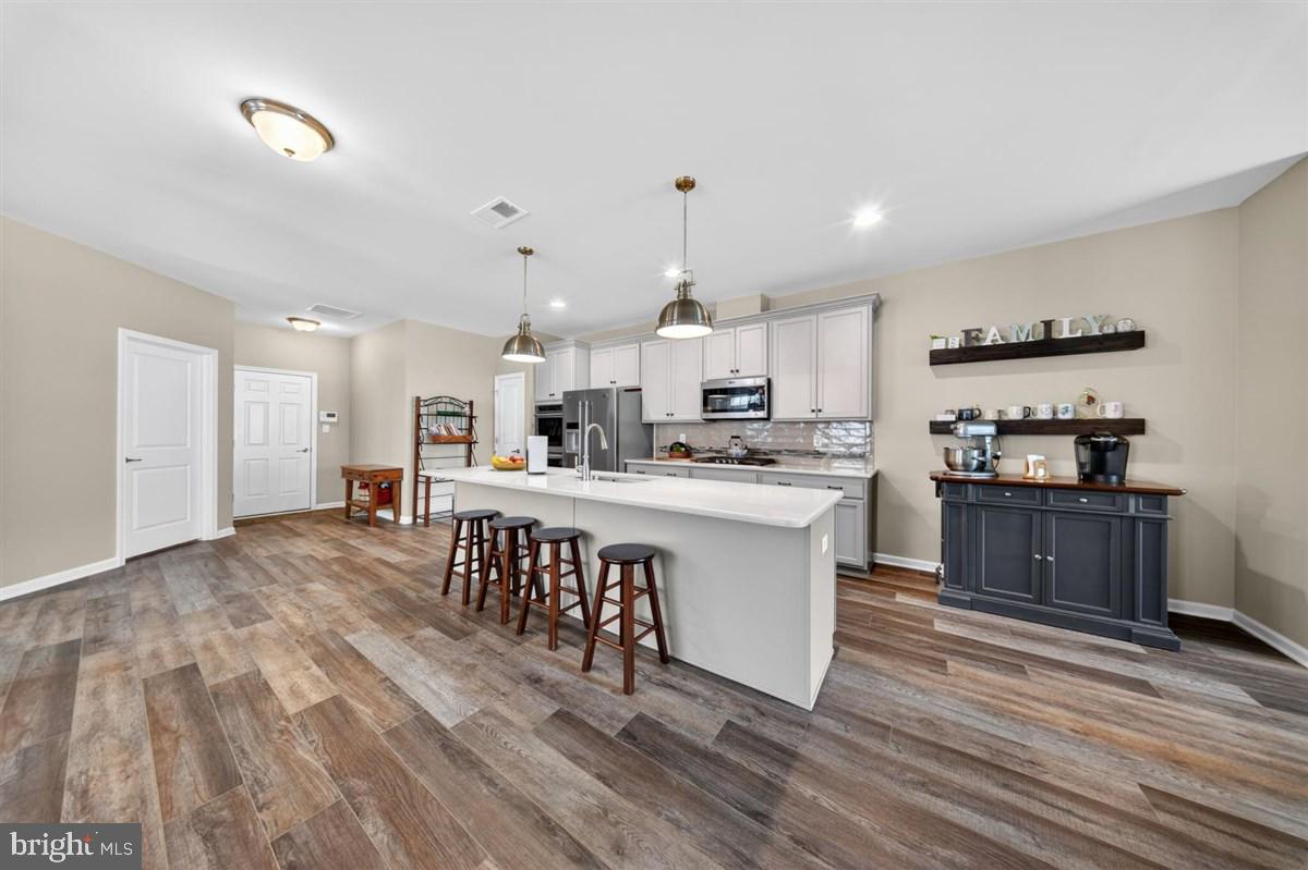 1426 Whispering Woods Road Middletown, DE 19709 - Photo 11 of 37 a kitchen with kitchen island wooden floors appliances and cabinets