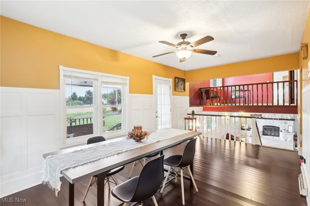 22120 Center Road Alliance, OH 44601 - Photo 19 of 41 Dining space with a decorative wall, ceiling fan, a wainscoted wall, and dark wood finished floors