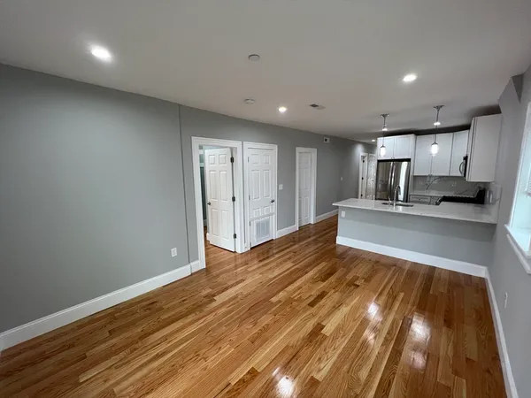 a view of empty room with wooden floor