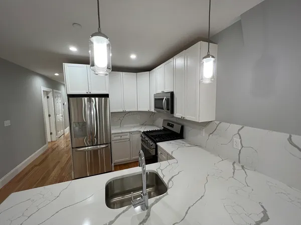 a kitchen with granite countertop a refrigerator sink and microwave