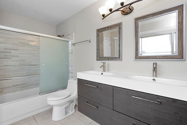 a bathroom with a toilet a sink a mirror a bathtub and shower