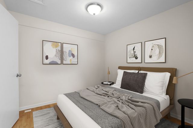 a view of an empty room with wooden floor and a bathroom