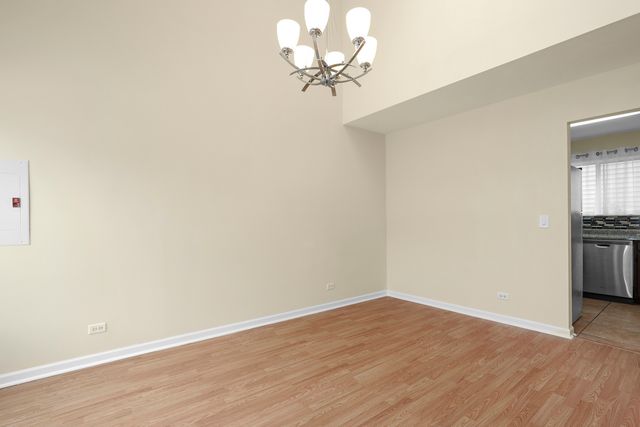 a view of a room with wooden floor and a ceiling fan