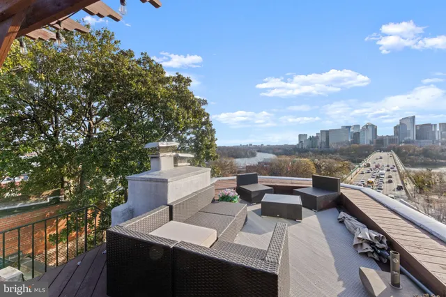 a view of roof deck with couches and potted plants
