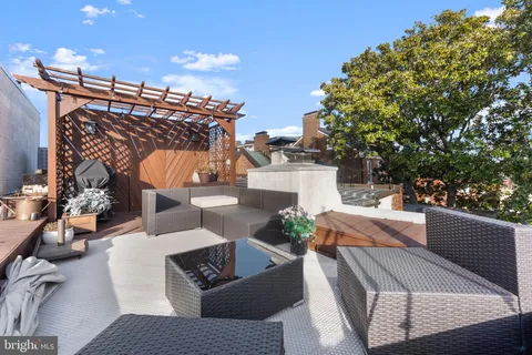 a view of a roof deck with couches and sky view