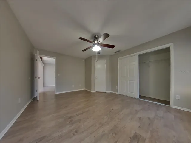 a view of an empty room with a ceiling fan