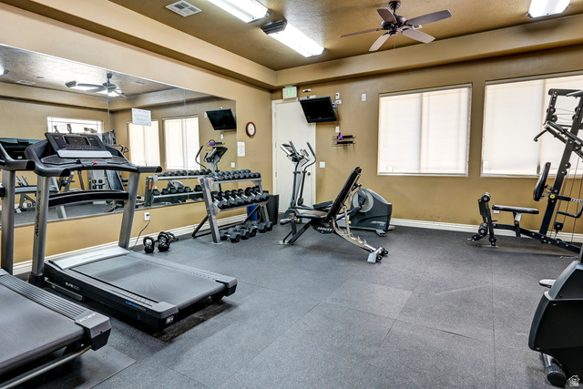 1177 Northfield Road, Unit 26 Cedar City, UT 84721 - Photo 39 of 45 Dedicated fitness room featuring durable rubber flooring, mirrored wall, multiple windows with blinds, ceiling-mounted light fixtures, and a ceiling fan