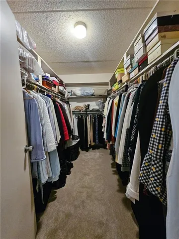 a view of walk in closet with clothes and shoes