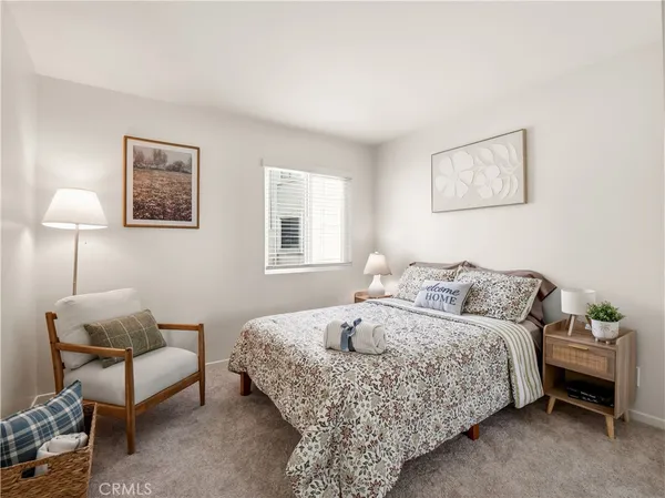 a bedroom with a bed and a lamp on dresser