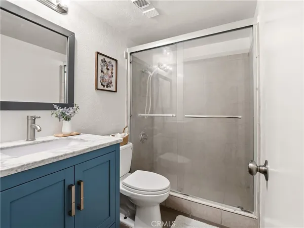 a bathroom with a granite countertop sink toilet and shower