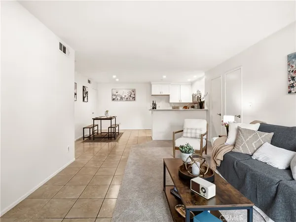 a living room with furniture and a dining table with kitchen view