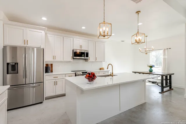 a kitchen with kitchen island white cabinets and white appliances