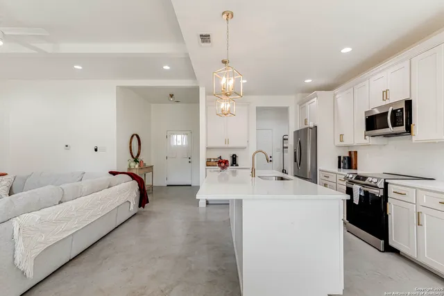 a large white kitchen with stainless steel appliances