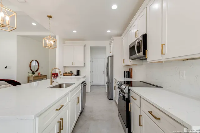 a kitchen with kitchen island white cabinets and refrigerator