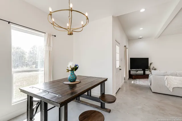 a kitchen with stainless steel appliances kitchen island granite countertop a table chairs and a refrigerator