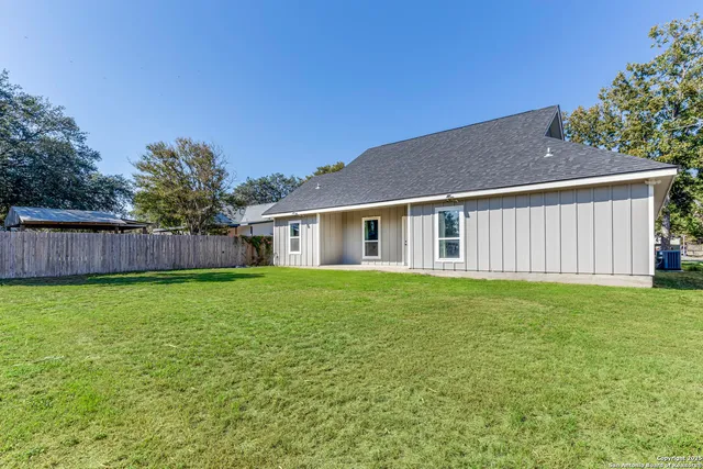 a view of a backyard with table and chairs and wooden fence