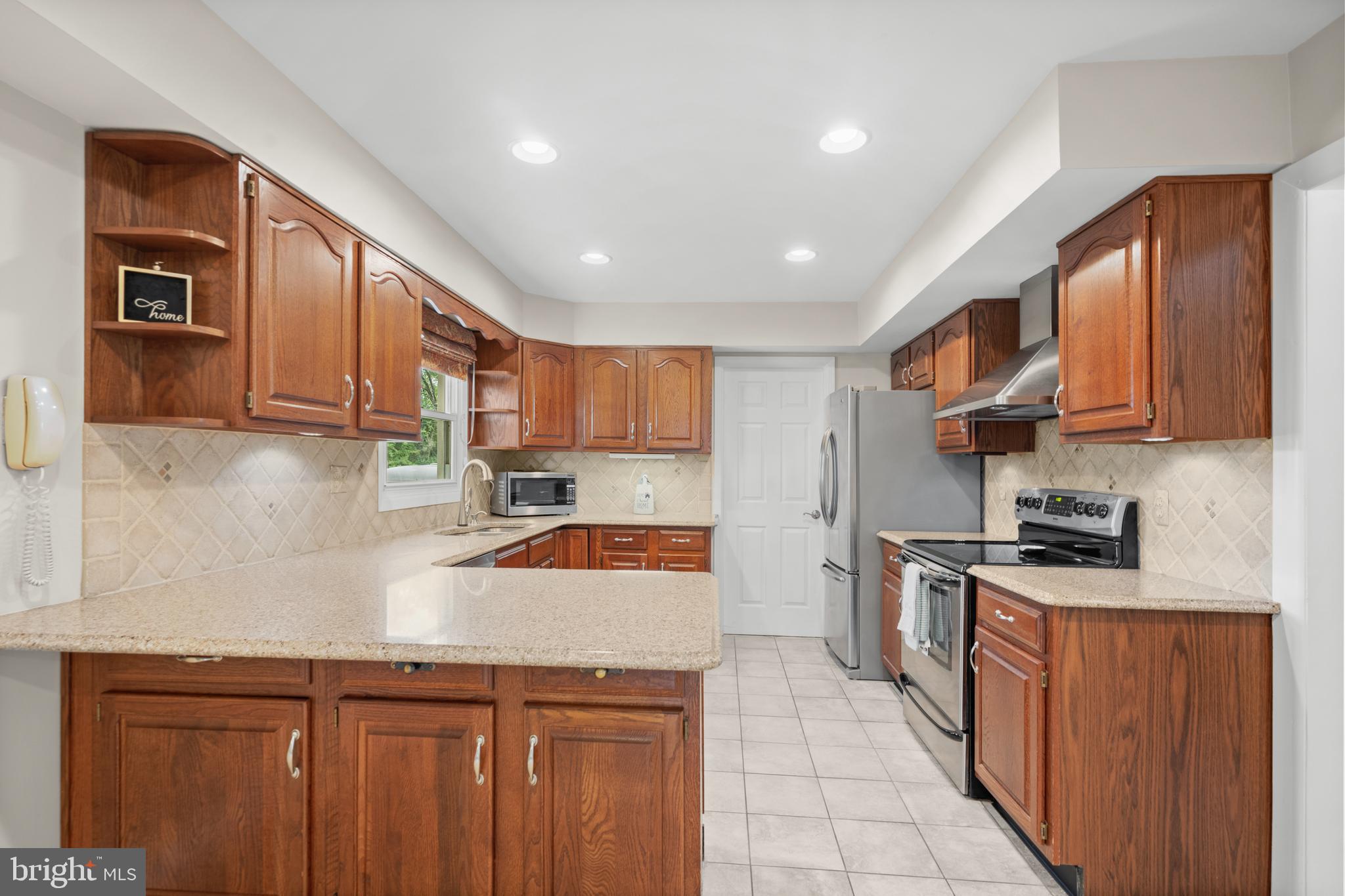 3402 Morlock Lane Bowie, MD 20715 - Photo 4 of 21 a kitchen with stainless steel appliances granite countertop wooden cabinets a stove top oven a sink and dishwasher
