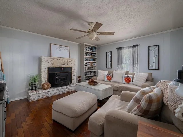 a living room with furniture a fireplace and a large window