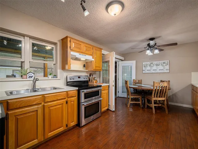 a kitchen with a table chairs stove and sink