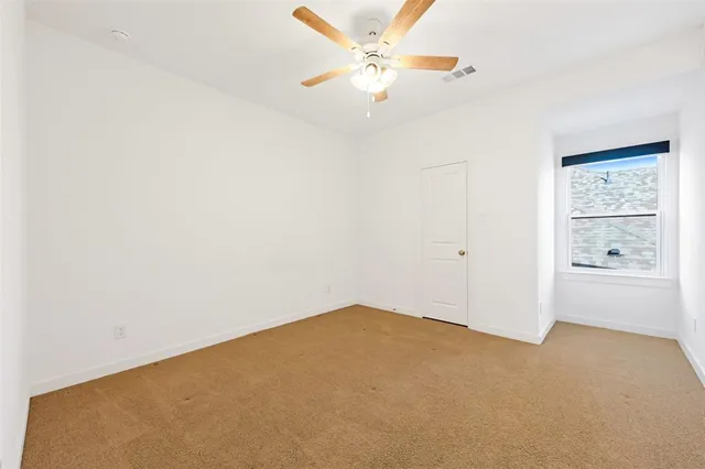 an empty room with closet and windows