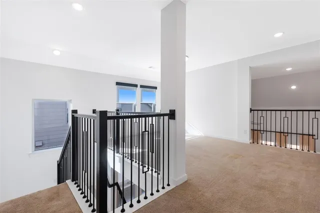 a view of staircase with railing and a rug