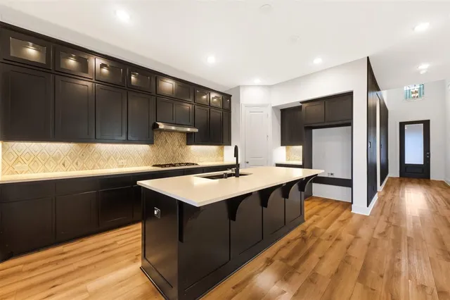 a kitchen with stainless steel appliances kitchen island granite countertop a sink stove and refrigerator