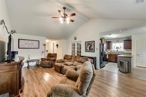 1300 Clegg Street Howe, TX 75459 - Photo 3 of 14 Vaulted ceiling living area featuring wood-finish flooring, a ceiling fan with integrated lighting, and an open concept to the kitchen
