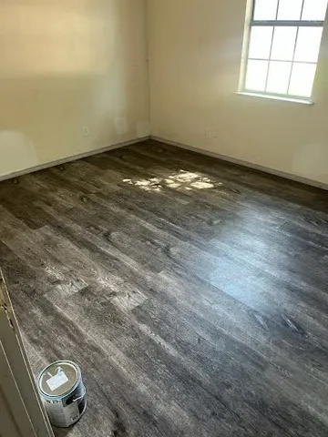 a view of a room with wooden floor and a window
