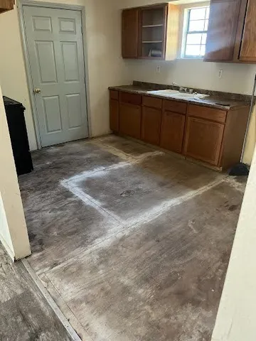 a kitchen with granite countertop a sink a stove and cabinets