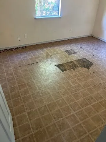 a view of a room with wooden floor and a window