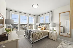 a bedroom with a bed and large windows