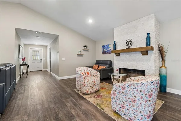 a kitchen with stainless steel appliances granite countertop a refrigerator a sink dishwasher a stove and a dining table with wooden floor