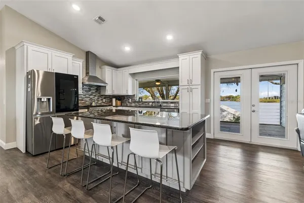 a kitchen with stainless steel appliances granite countertop a sink and wooden cabinets