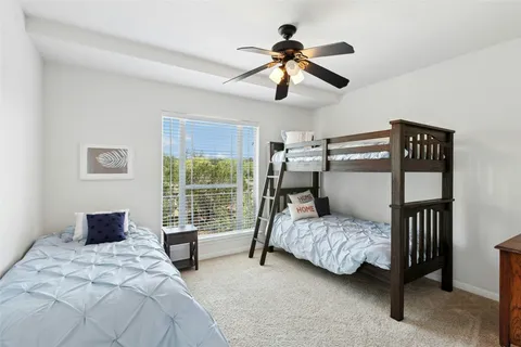 a bedroom with a bed a chandelier and a window