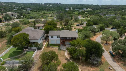 an aerial view of residential houses with outdoor space and trees