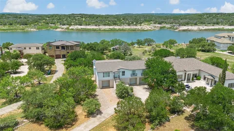an aerial view of a residential houses with outdoor space and lake view