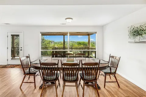 a view of a dining room with furniture large windows and wooden floor