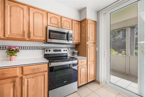 a kitchen with granite countertop a refrigerator stove and cabinets