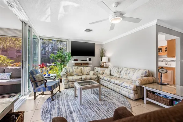 a living room with furniture a flat screen tv and a large window