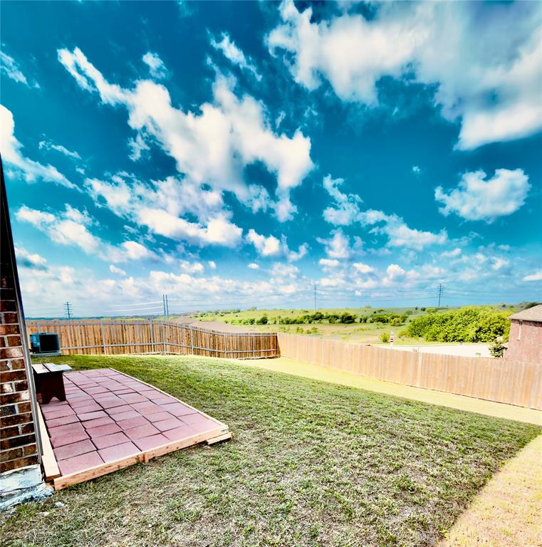 196 Cattlemans Crk Road West Newark, TX 76071 - Photo 20 of 24 Expansive outdoor space featuring a red paver patio area, green lawn, and wood privacy fencing