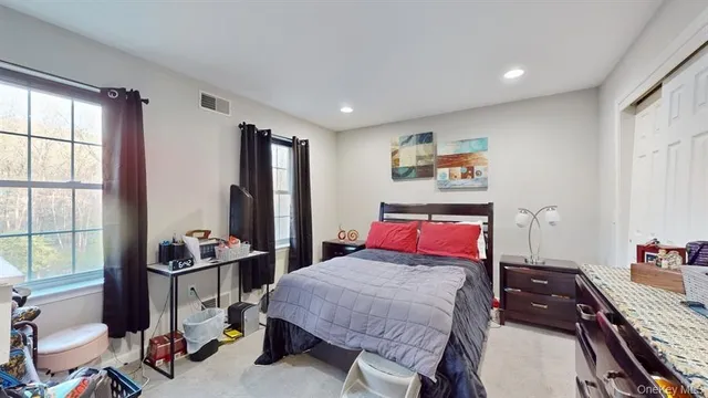 a bedroom with a bed and large windows