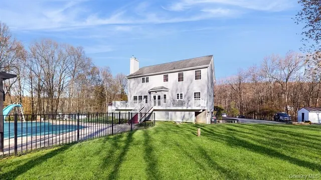 a view of a house with a big yard and large trees