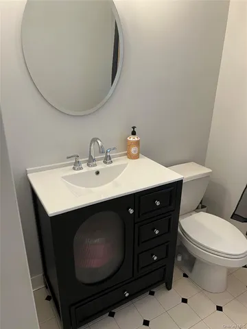 a bathroom with a sink vanity mirror and toilet