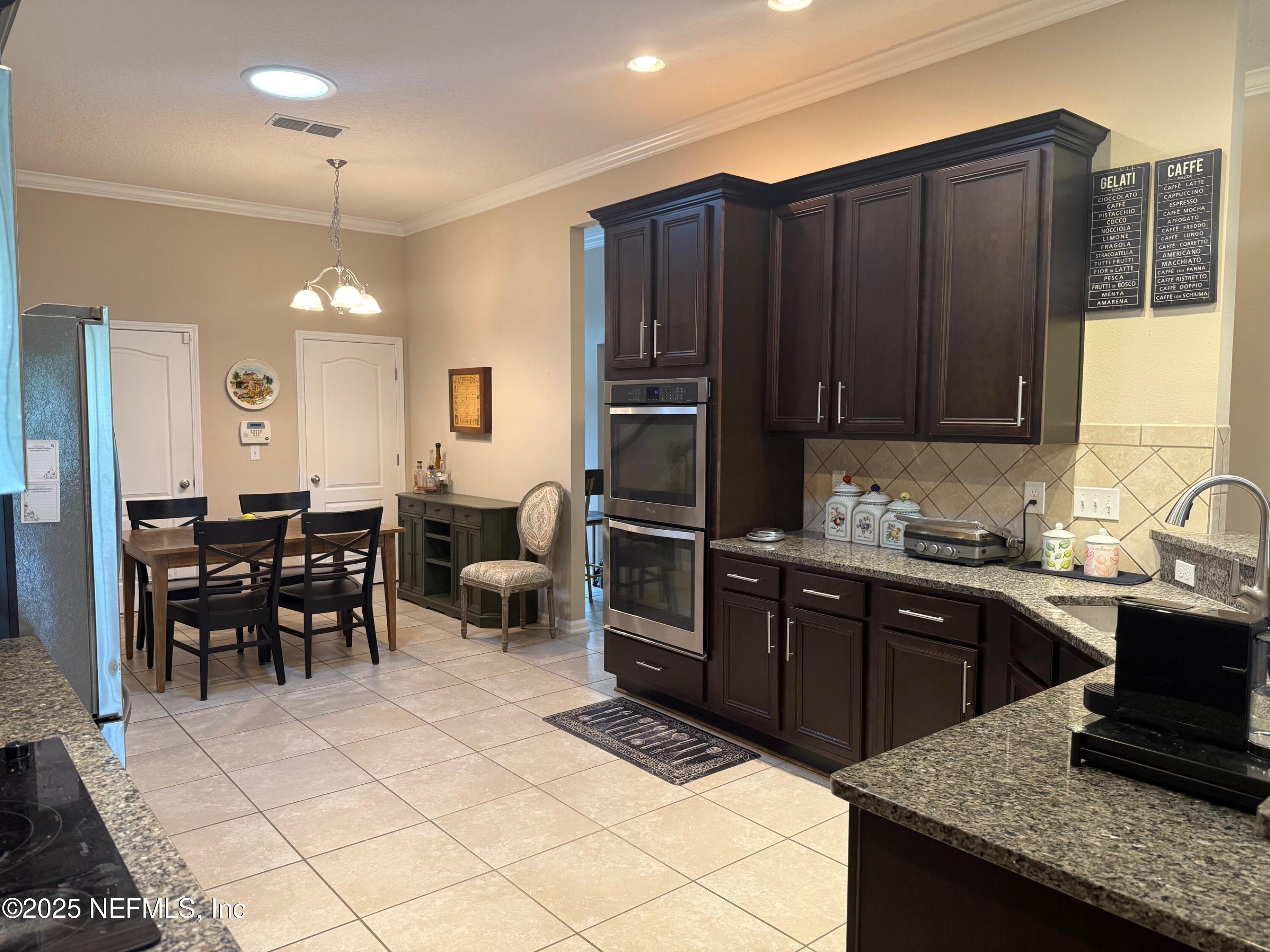 486 Porta Rosa Circle St. Augustine, FL 32092 - Photo 12 of 38 a kitchen with granite countertop a sink cabinets and stainless steel appliances