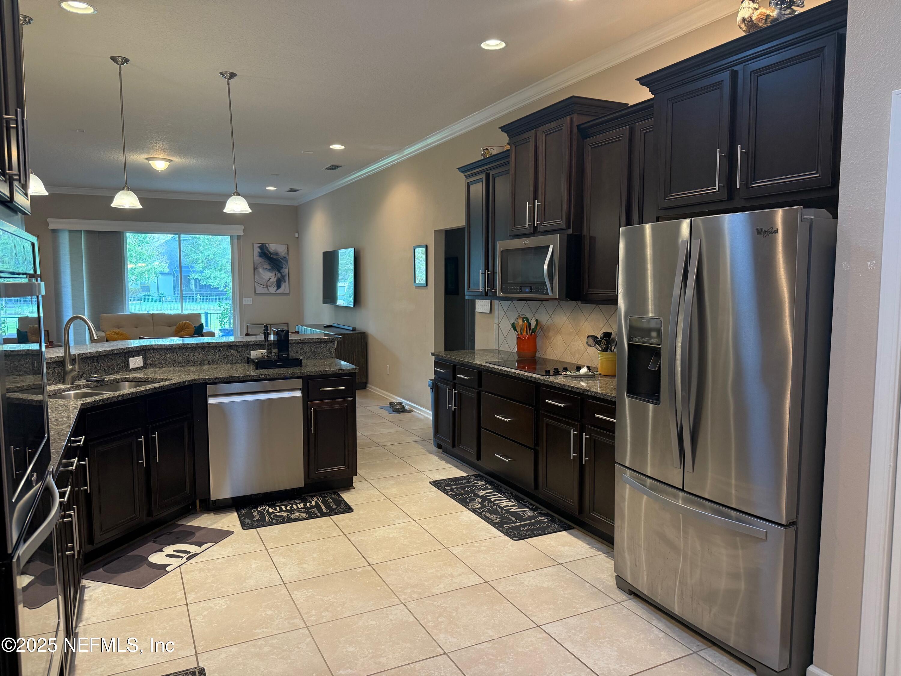 486 Porta Rosa Circle St. Augustine, FL 32092 - Photo 16 of 38 a kitchen with granite countertop stainless steel appliances and wooden cabinets
