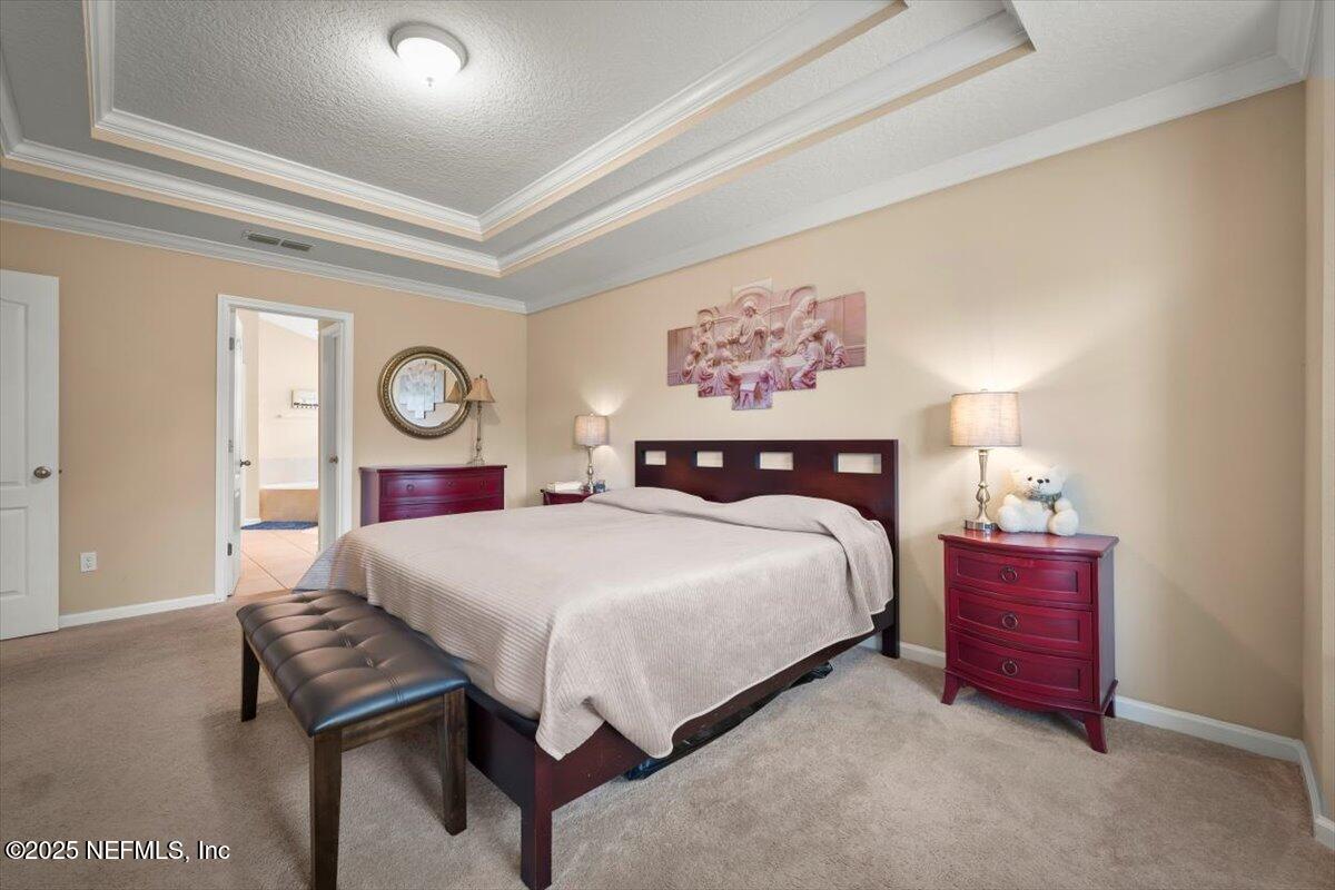 486 Porta Rosa Circle St. Augustine, FL 32092 - Photo 22 of 38 a bedroom with a bed and a chandelier